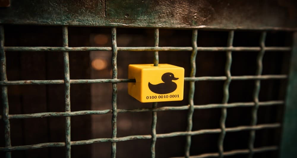 Physical puzzle clue attached to a metal grid in the Sato Code outdoor escape game